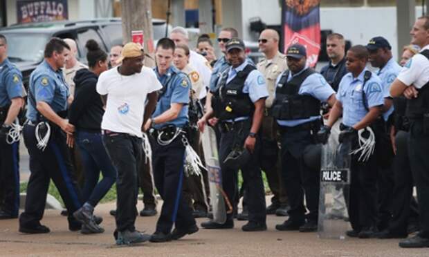 Police arrest a demonstrator during a protest along interstate highway 70 on 10 September  near Ferguson, Missouri.