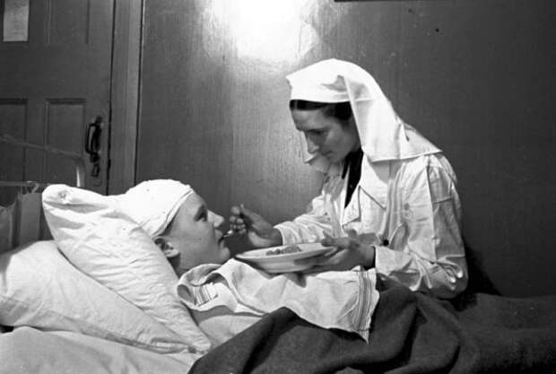 Медсестра Козлова А. кормит раненого майора Ногина В. в госпитале № 2-386. Медсестра Козлова А. кормит раненого майора Ногина В. в госпитале № 2-386.