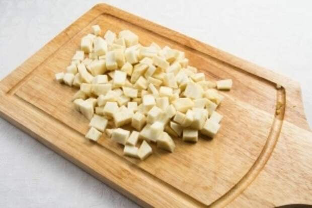 Почистить корень сельдерея. Нарезать его кубиками.