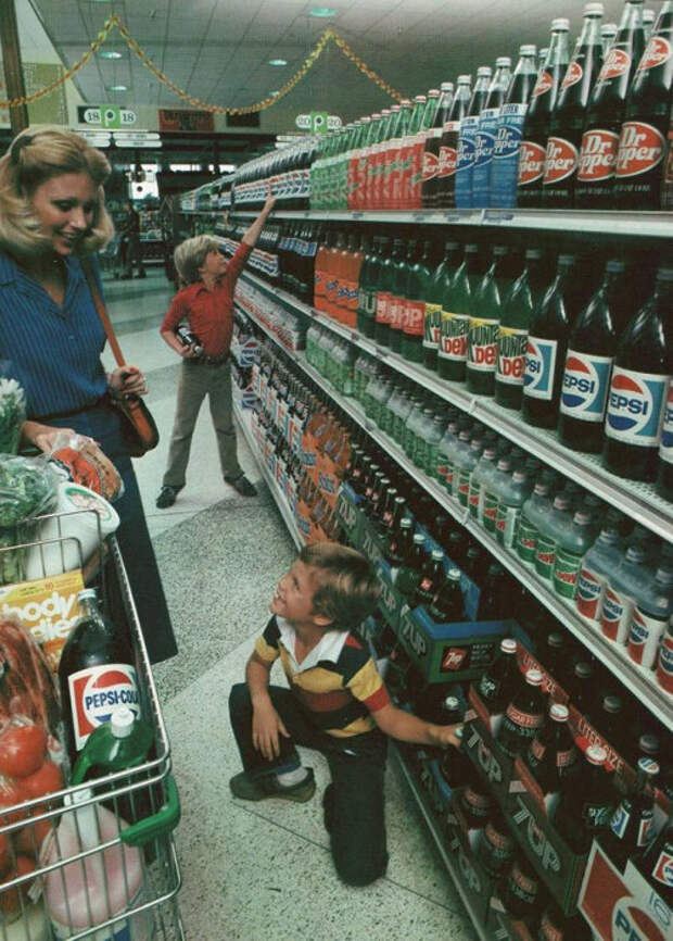 На полке стоят бутылки безалкогольных напитков в таре из стекла. 1980 год.