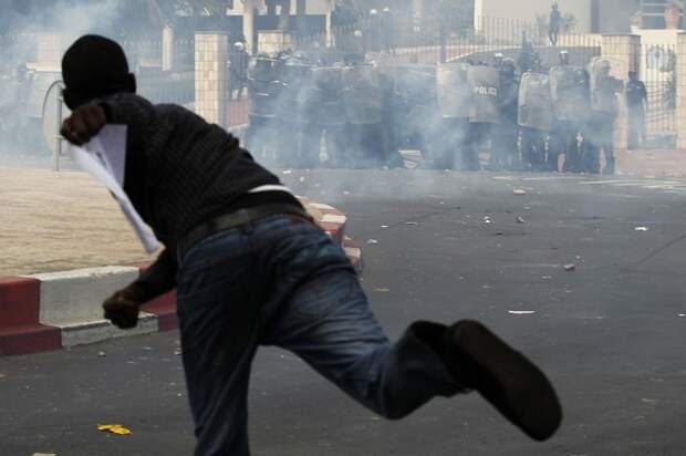 A demonstrator throws a rock towards riot police during a demonstration in Senegal's capital Dakar