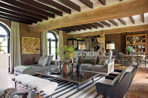 Деревянные балки на потолке и каменный пол в интерьере французского дома