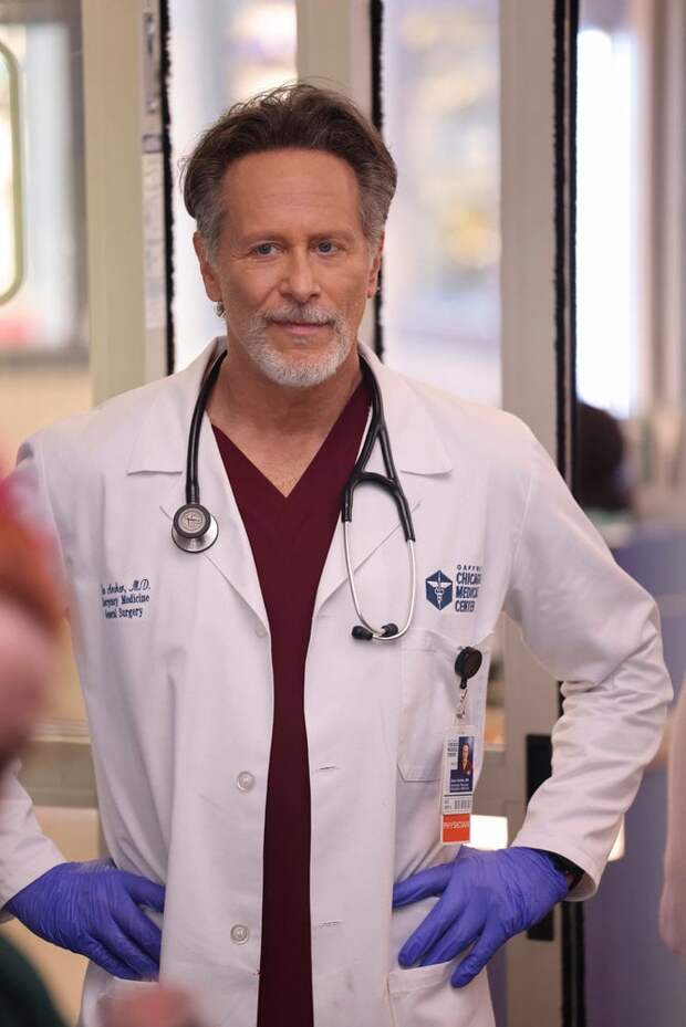 Archer wearing purple gloves and standing with his hands on his hips on Chicago Med Season 10 Episode 13