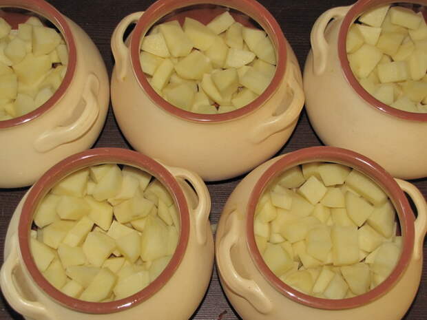 Разложить подготовленный картофель. пошаговое фото этапа приготовления картошки с мясом в горшочках