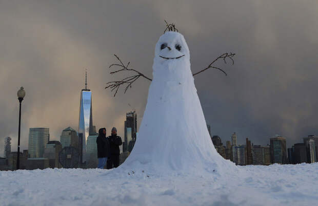 Снеговик сидит напротив нижней части Манхэттена в Нью-Йорке