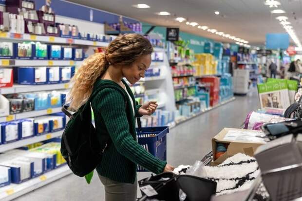 Consumer shopping with basket in a discount store
