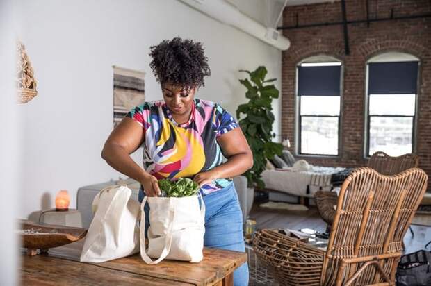 A woman unpacking grocery bags in her home.