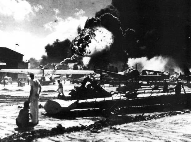 Аэродром на базе ВМС США на острове Форд острова. На заднем фоне видно пламя от горения морских судов после нападения японцев, 7 декабря 1941 года.. Пёрл Харбор, история, факты