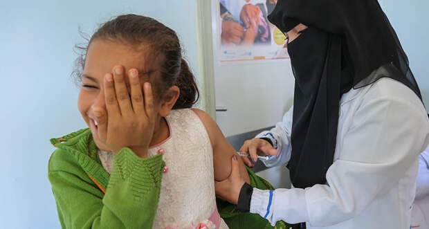 girl in Yemen getting measles shot