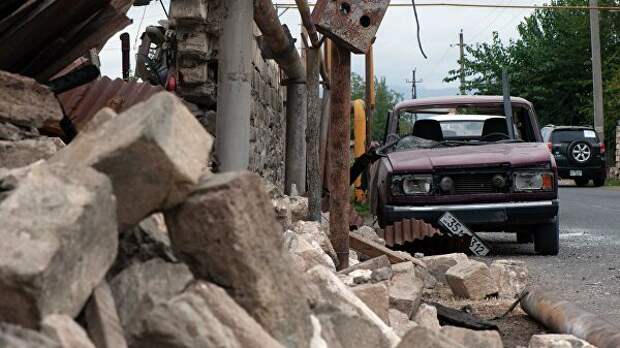 Поврежденный дом и автомобиль в результате обстрелов по общине Иванян Нагорного Карабаха