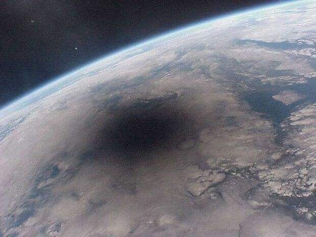 Вид Земли с МКС, а чёрное пятно - это тень от луны, во время солнечного затмения