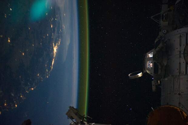 На снимке видно астронавтов в светящемся модуле МКС Купол. Станция пролетает над Брисбеном (Brisbane), Австралия.