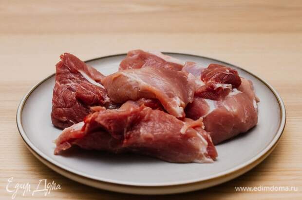 Мясо нарезать крупными кусочками и слегка посолить с двух сторон.