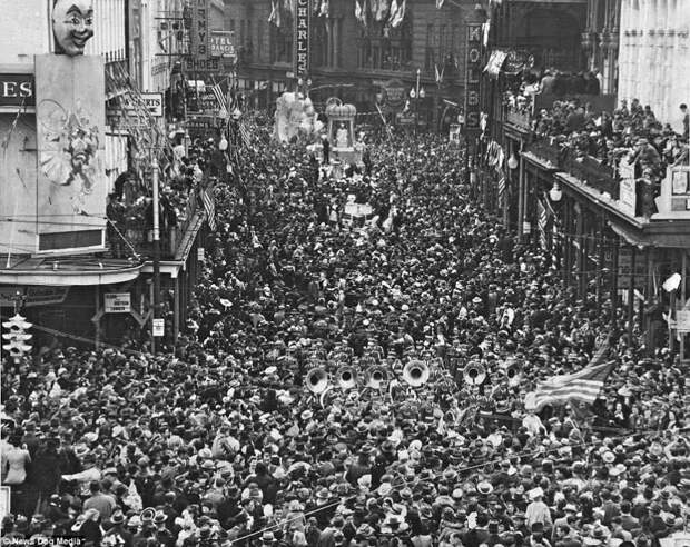 Толпа шествует по улицам города во время знаменитого карнавала "Марди Гра", примерно 1900 год америка, исторические кадры, история, люди, новый орлеан, редкие фото, сша, фото