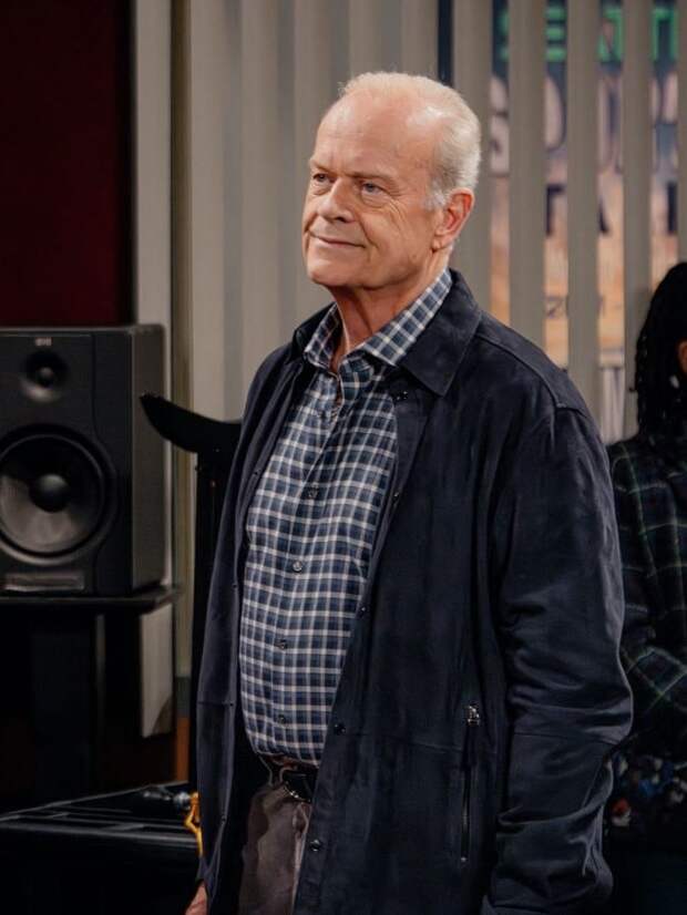Frasier in navy cardigan stands at KACL
