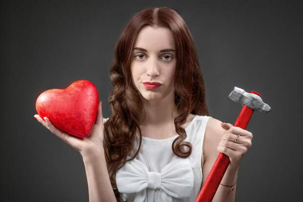 Upset woman holding broken heart and hammer on grey background. Failed relationship concept, Image: 215558560, License: Royalty-free, Restrictions: , Model Release: yes, Credit line: Profimedia, Alamy