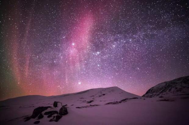 Мерцание красных, фиолетовых, зеленоватых цветов на звездном небе.