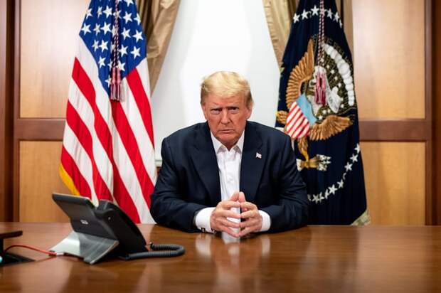 Former President Donald Trump on a conference call while seated at a desk.