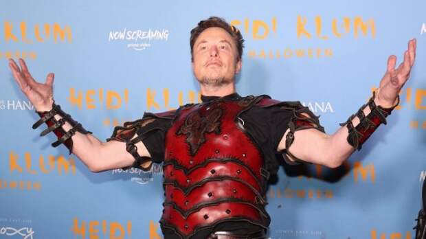 elon musk in a halloween costume holding his hands up