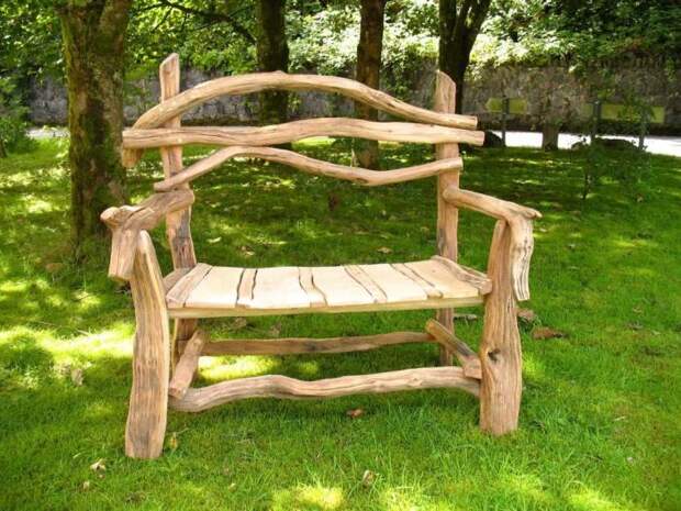 Деревянная скамейка из светлой породы древесины в саду. 