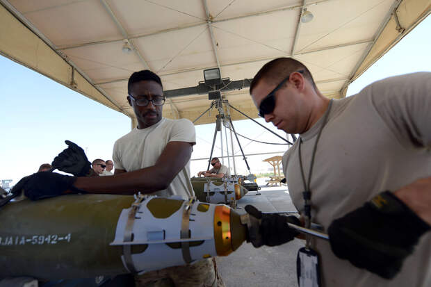 U.S. Air Force Staff Sgt. Terrin Love, a native of Montgomery, Ala., and Senior Airman William Spencer, a native of Kansas City, Mo., work together to tighten the tail end of a GBU-38 bomb at Bagram Airfield, Afghanistan Aug. 14, 2014. The GBU-38 is a vit