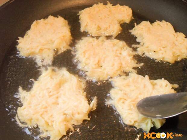 шесть сырых картофельных драников на сковороде с маслом и ложкой