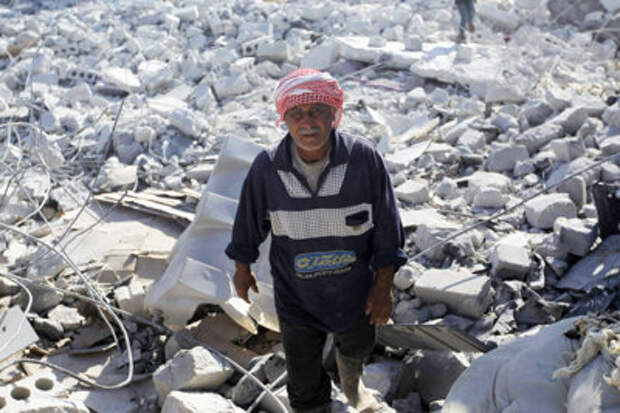 CLICK IMAGE for slideshow: A man inspects a damaged site in what activists say was a U.S. strike in Kafr Daryan, in Syria's Idlib Province, on Sept. 23, 2014. (REUTERS/Abdalghne Karoof)