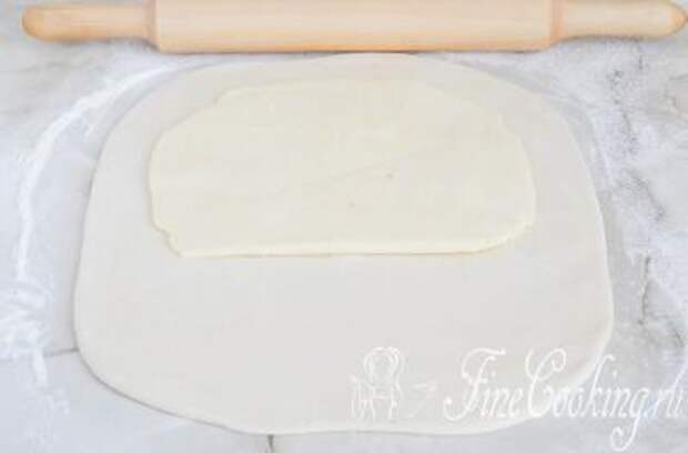 Шаг 14. Визуально делим тесто на 3 части и кладем на 1/3 масляный пласт, оставляя с краев по паре сантиметров